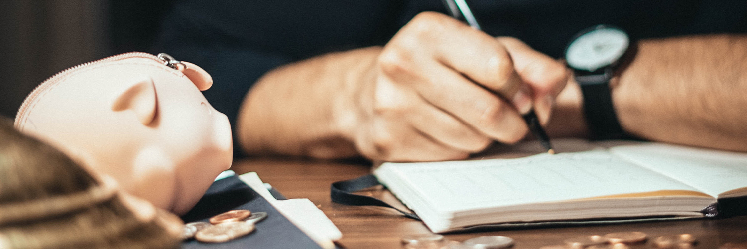 A man sitting at a desk writing in a notebook